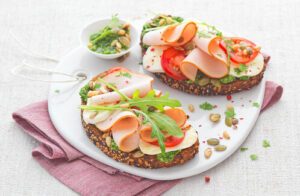 Tartine de pain complet au fromage frais, jambon blanc et crudités